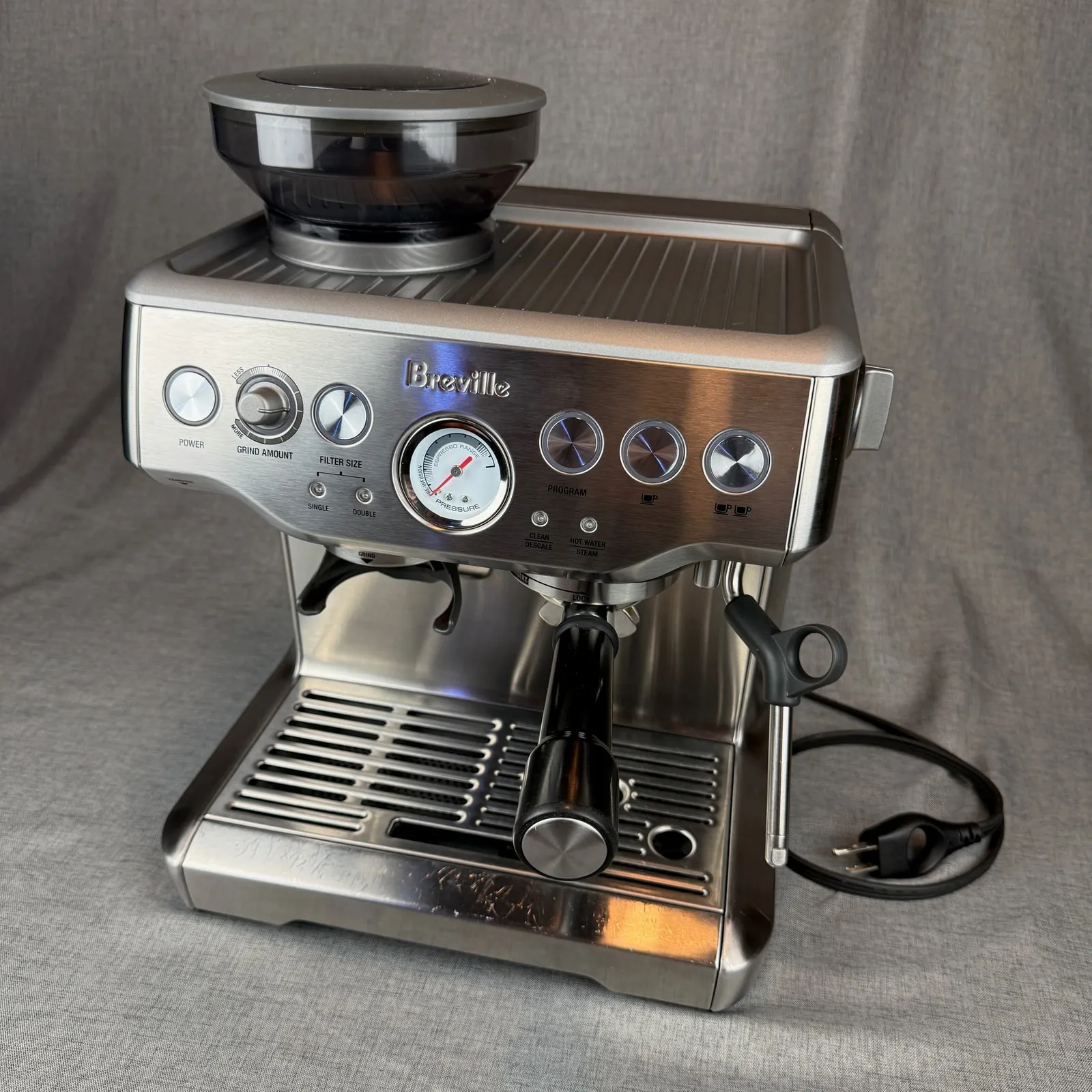 Breville Barista Express BES870XL espresso machine in brushed stainless steel, its portafilter in the group head