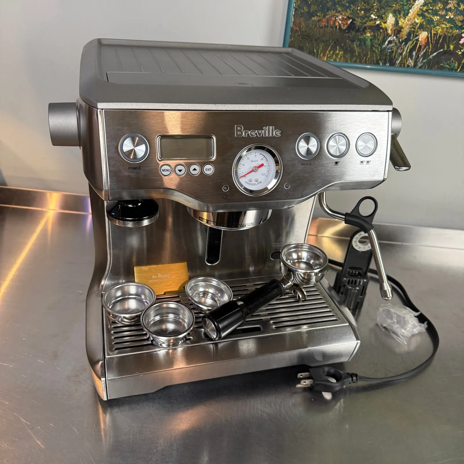 Breville Dual Boiler BES920XL espresso machine with its portafilter and filter baskets